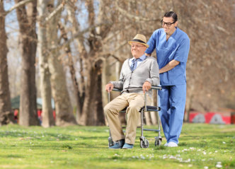 caregiver walking with senior patient in park