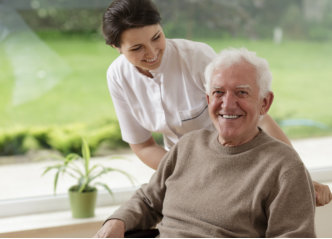 smiling senior man staying with caregiver