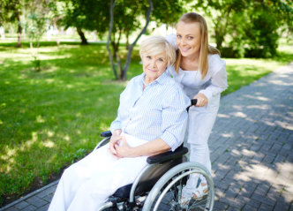 caregiver walking with senior patient in park